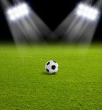 Campo iluminado con balón de fútbol